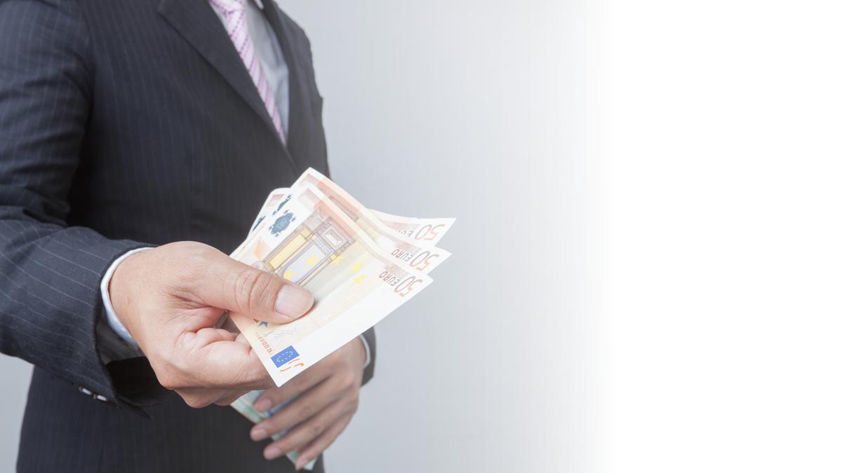 Mano che consegna banconote: somme recuperate